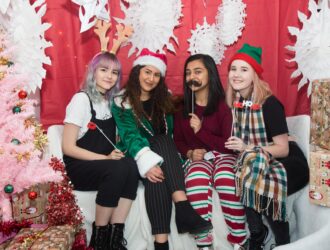 Four university students having photo in Christmas grotto