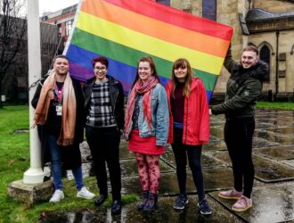 Students holding LGBT flag outside Huddersfield university